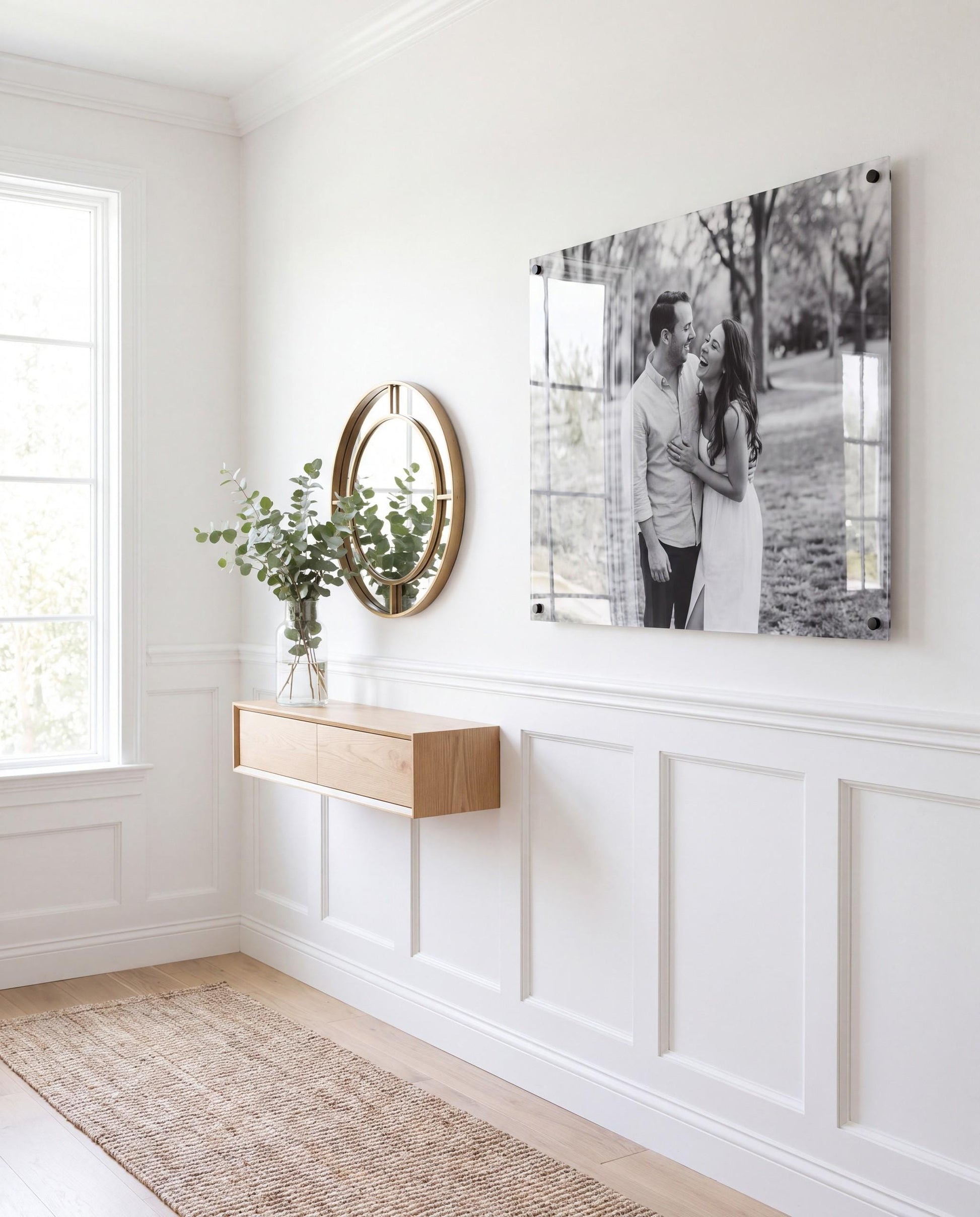 Black and white acrylic couple photo print mounted in a bright modern hallway with black standoffs