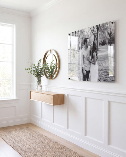 Black and white acrylic couple photo print mounted in a bright modern hallway with black standoffs