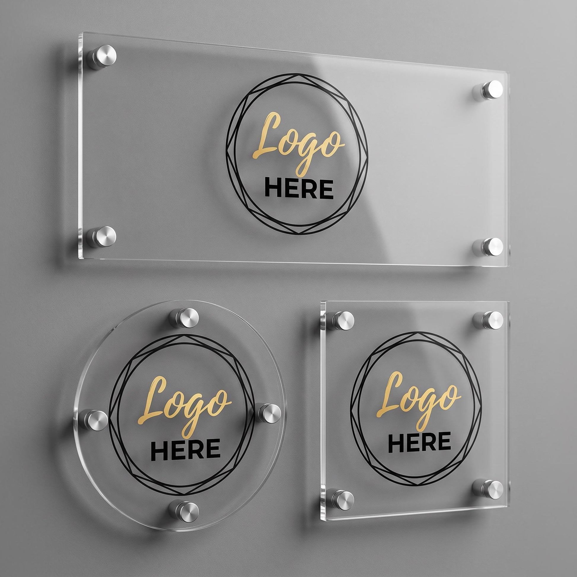 Three custom acrylic business logo plaque shapes, rectangle, circle, and square, with silver standoff mounts on a gray wall