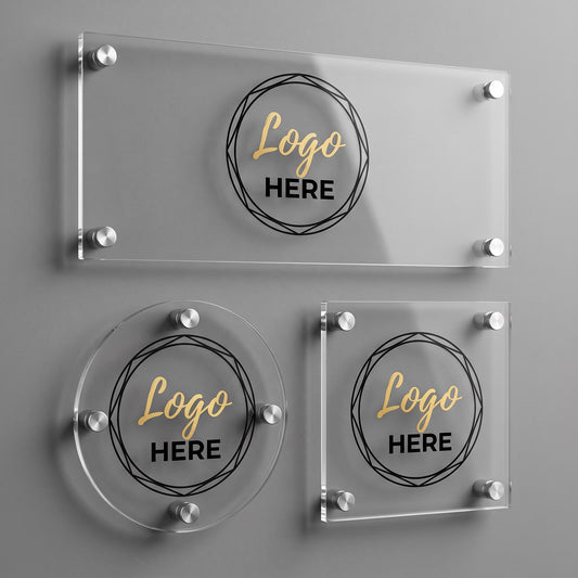 Three custom acrylic business logo plaque shapes, rectangle, circle, and square, with silver standoff mounts on a gray wall