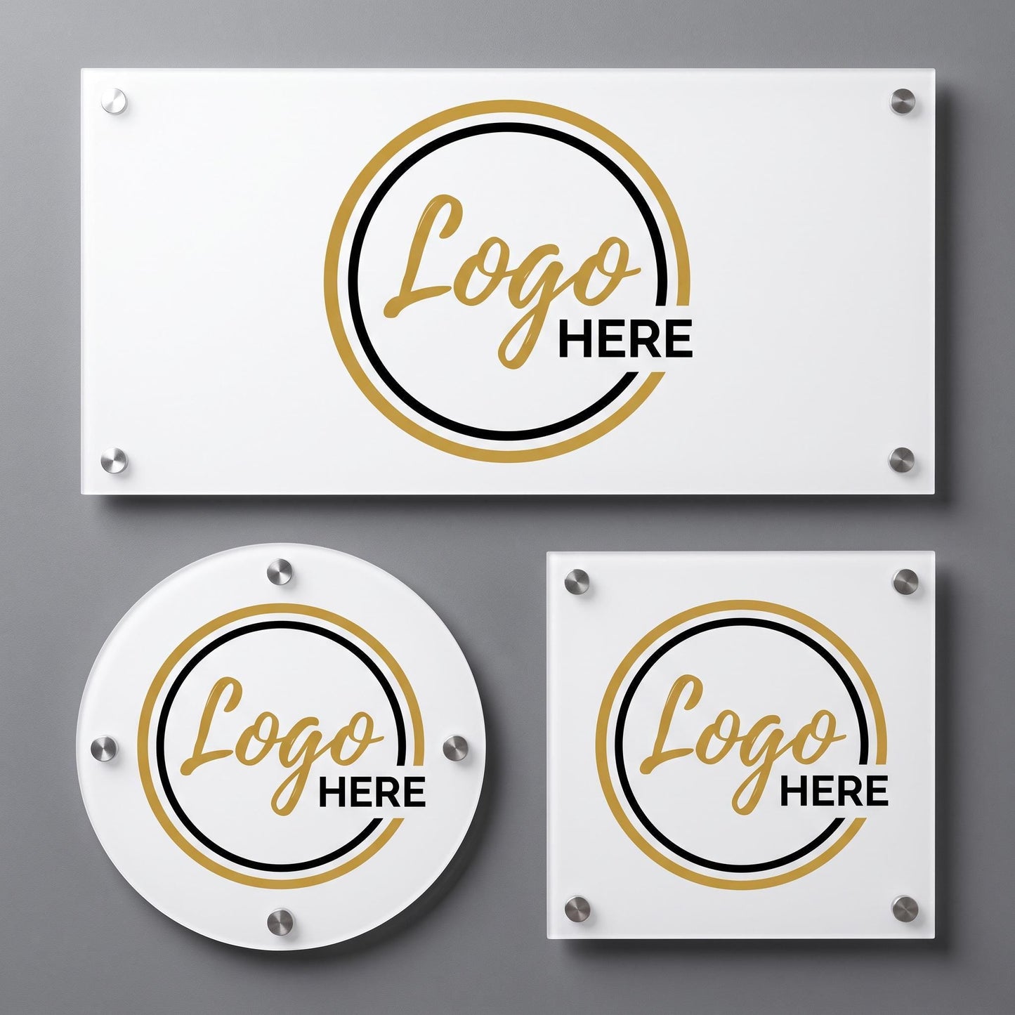 Three white acrylic logo plaques with gold and black circular emblem design and standoff mounts on a gray wall