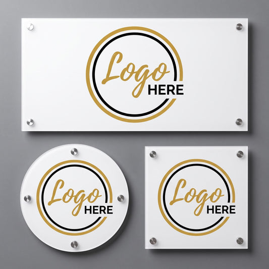 Three white acrylic logo plaques with gold and black circular emblem design and standoff mounts on a gray wall