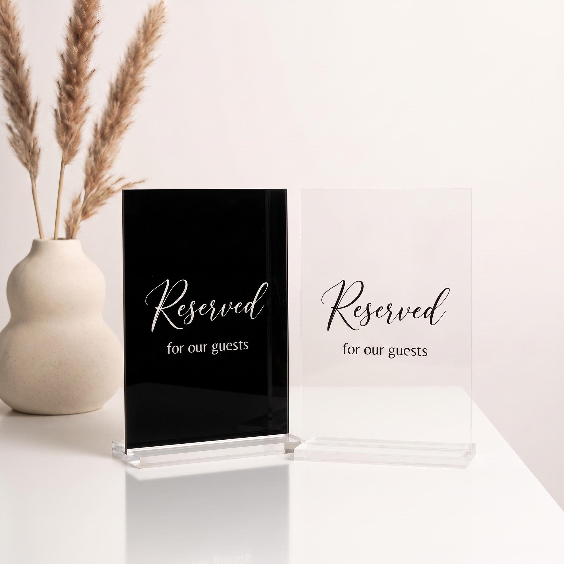 Two acrylic color options for the table sign: black acrylic with white text and clear acrylic with black text.