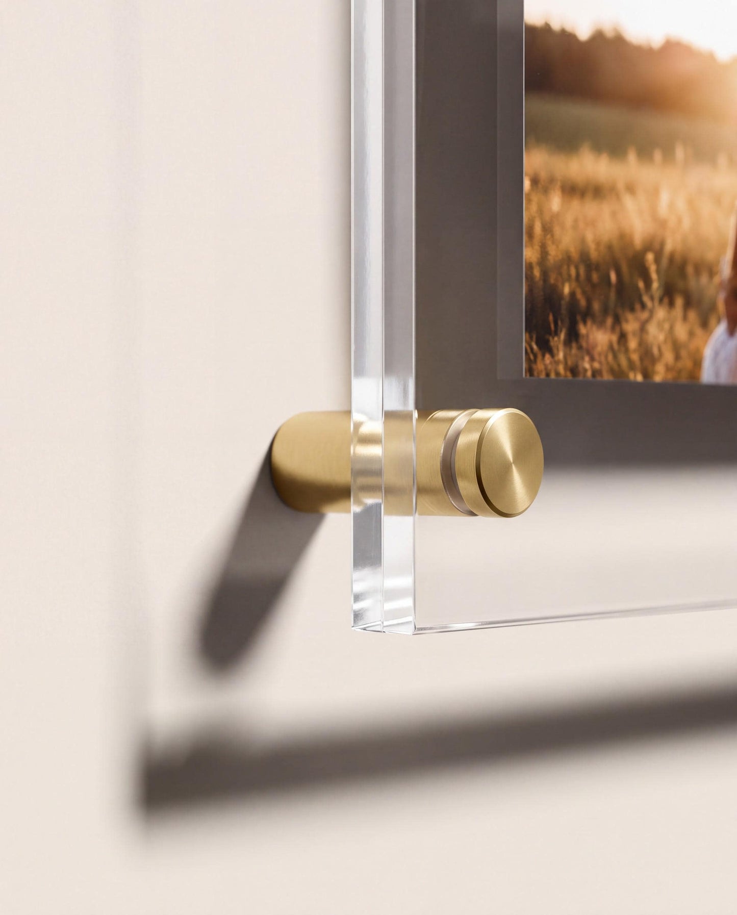 Close up of gold standoff mount holding acrylic photo panel off the wall showing floating effect