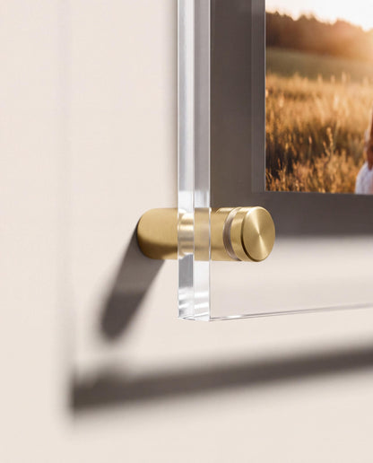 Close up of gold standoff mount holding acrylic photo panel off the wall showing floating effect