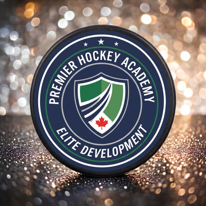 Close-up of custom hockey puck showing detailed printed navy and green crest logo with maple leaf emblem