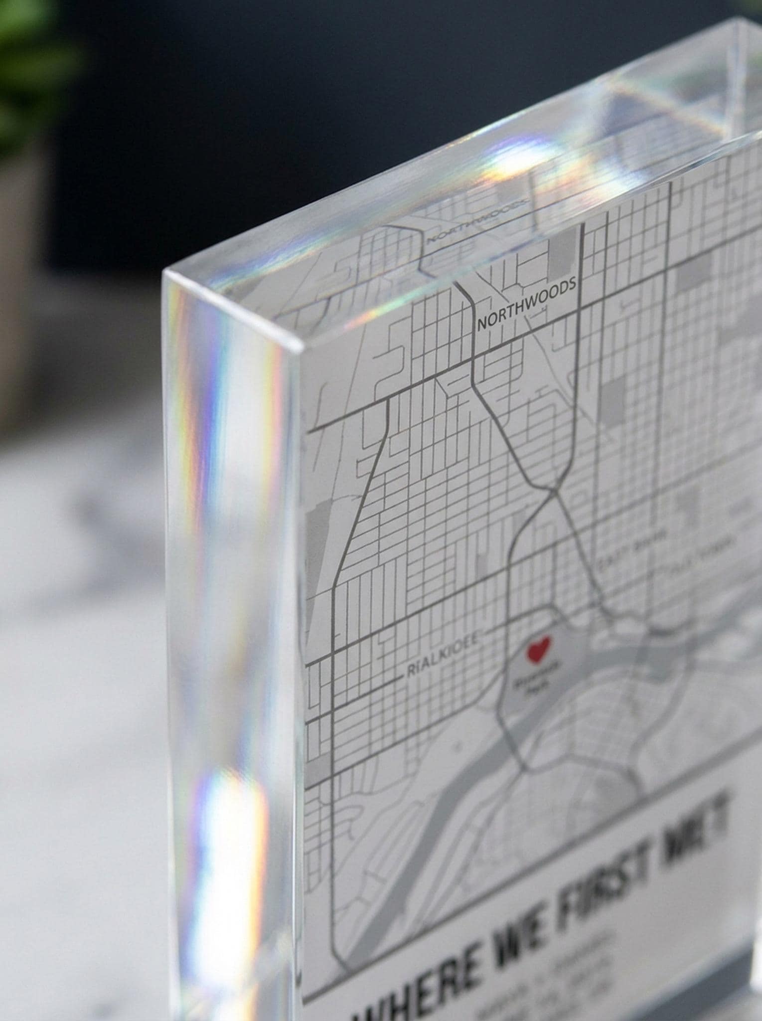 Close-up of acrylic map block beveled edge showing engraved street map detail and light refraction
