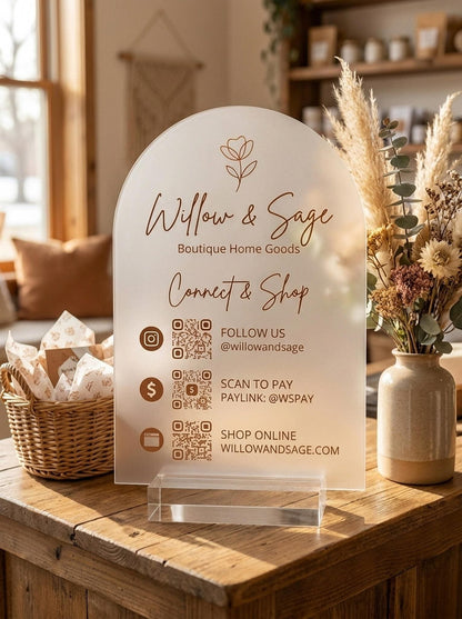Custom QR code acrylic sign displayed on a boutique shop counter with dried flowers