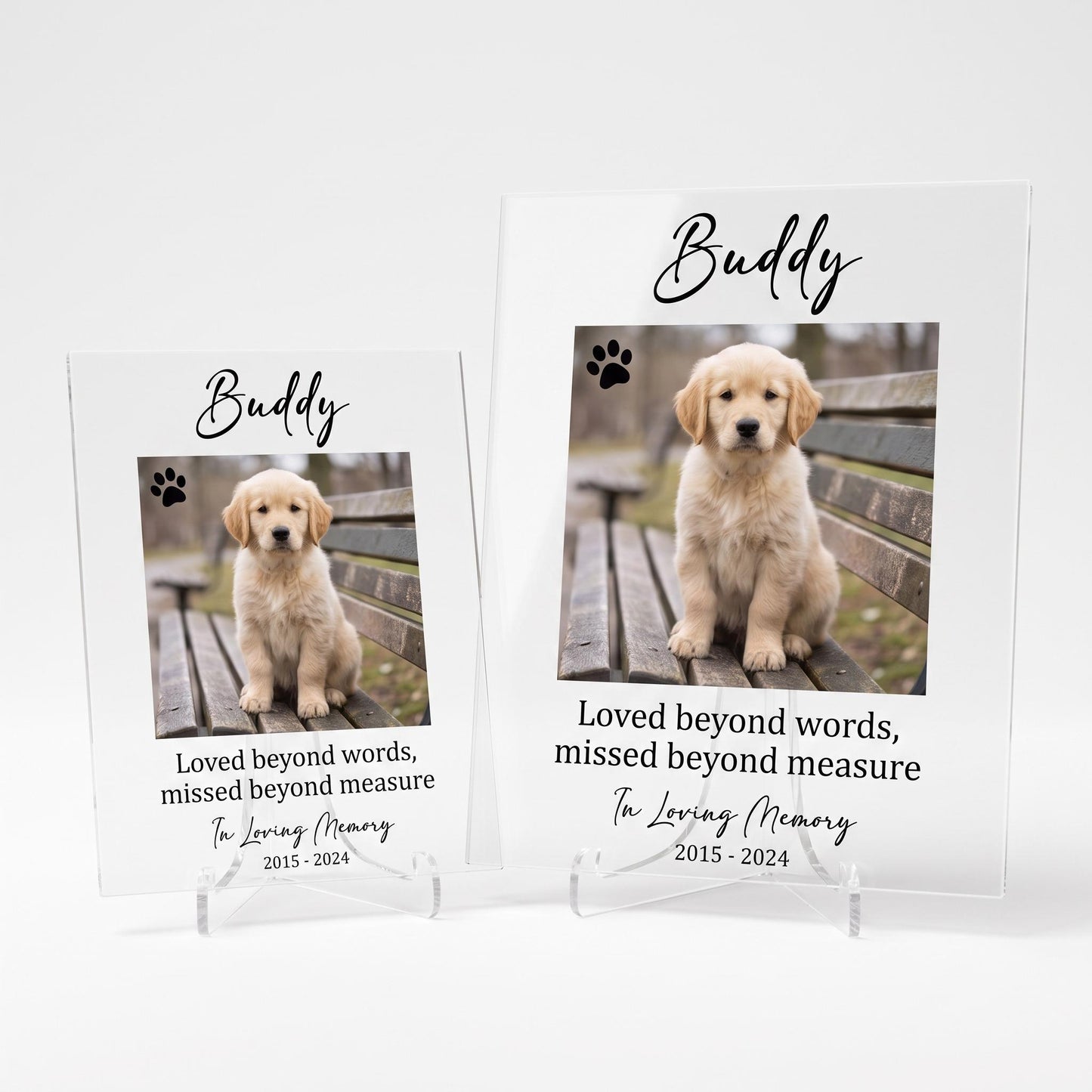 Two size options for the pet memorial plaque shown side by side, smaller and larger, both on clear acrylic stands.