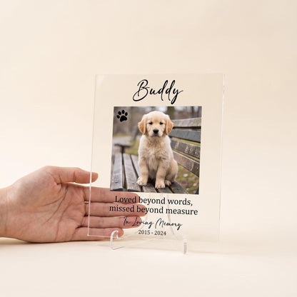 Clear acrylic pet memorial plaque on its stand next to a hand to show its compact tabletop size.